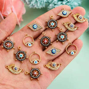 Vue macro de breloques œil maléfique colorées en alliage avec strass tenues en main