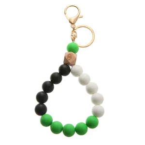 Detail of colorful silicone beads keychain with engraved wooden bead and gold lobster clasp