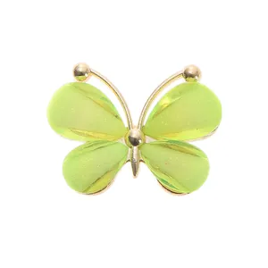 Detailed macro view of a lime green acrylic butterfly charm with a gold-tone alloy frame