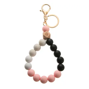 Detail of silicone beaded keychain with pink beads and engraved hexagonal wooden bead