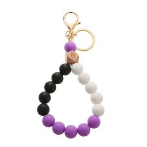 Close-up of silicone beaded keychain with engraved wood bead and gold hardware