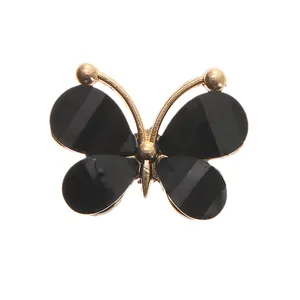 Detailed view of DIY acrylic butterfly shoe charm with black stripes and golden metal frame