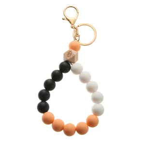 Detail of colorful silicone beaded keychain wristlet with engraved wooden bead and gold clasp