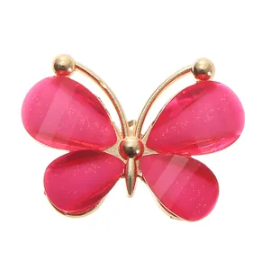 Detail of pink acrylic butterfly shoe charm with gold metal frame and glittery wings