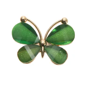 Detail of emerald green butterfly shoe charm with gold trim and sparkling glitter
