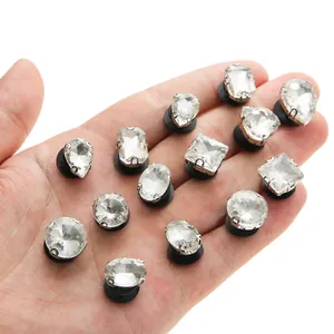Close-up of various crystal glass shoe charms in diverse shapes held in hand