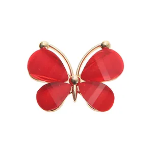 Detail of red acrylic butterfly charm with gold metal frame for garden shoe decoration