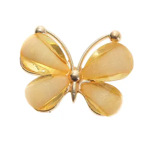 Detailed view of DIY butterfly shoe charm with gold frame and yellow glitter wings