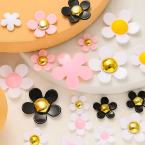 Detailed view of colorful resin flower shoe charms on orange and white geometric stands