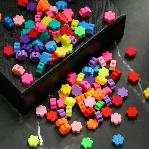 Vue détaillée de perles fleurs colorées en pâte polymère avec trous pour bijoux artisanaux
