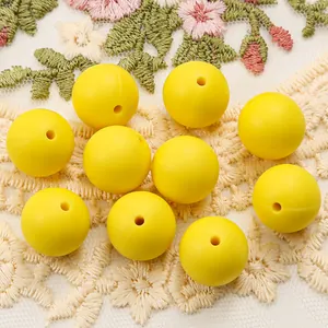 Close-up of ten bright yellow matte silicone beads for DIY jewelry and bracelet making