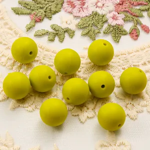 Detail of 10 fluorescent green 15mm silicone beads with matte finish on lace fabric