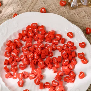 Vue détaillée de perles coeur rouges avec texte LOVE pour bijoux artisanaux