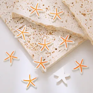 Detail van mini hars zeester hangers voor DIY sieraden op een getextureerde travertijn