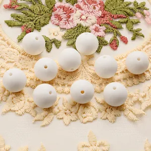 Close-up of 15mm white silicone round beads with center holes on lace fabric