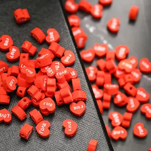 Vue macro de perles en cœur rouges avec texte LOVE blanc pour la création de bijoux
