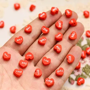 Vue macro de petites perles en cœur rouges avec texte LOVE pour la création de bijoux