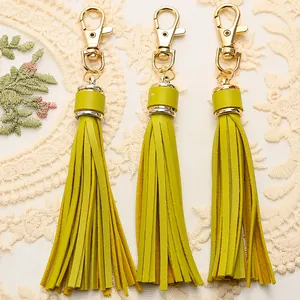 Detailed close-up of lime green PU leather tassels with gold-tone lobster clasps for bags