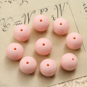 Detailed close-up of 15mm pink silicone beads with central hole for DIY jewelry making