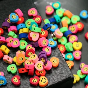 Gros plan de perles en argile colorées en forme de cœur avec visages souriants pour bijoux
