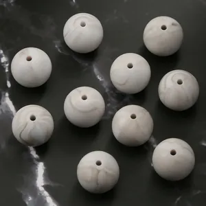 Detailed view of 15mm round silicone beads with white and tan marble texture for DIY jewelry