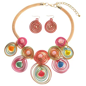 Detailansicht von bunten Spiralen-Anhängern an einer goldenen Netz-Halskette im Boho-Stil