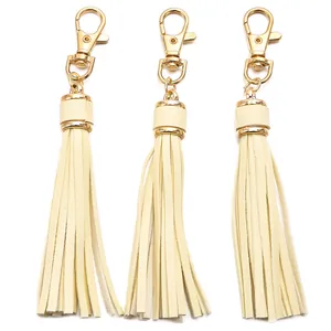 Three cream white PU leather tassels with gold lobster clasps and swivel ring hardware