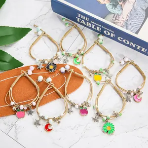Bohemian ceramic beaded bracelets set with moon star flower pendants on marble backdrop
