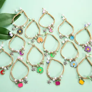 Handmade woven ceramic bracelets with star moon and flower pendants on green background