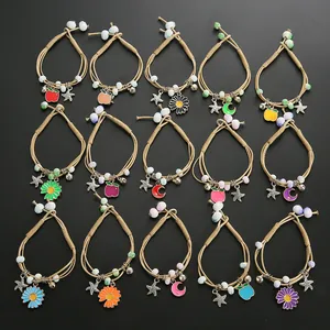 Detailed set of 15 handmade woven bracelets with colorful enamel charms on black background