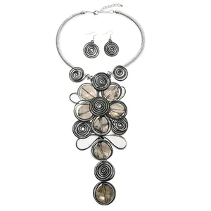 Detailansicht eines Ethno-Schmucksets mit Metallspiralen und braunen Harz-Edelsteinen