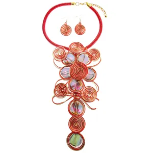 Detailansicht des handgefertigten Stammes-Schmucksets mit roten Drahtspiralen und Steinen