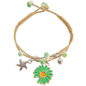 Detail of adjustable woven rope bracelet with starfish, daisy, and bell charms