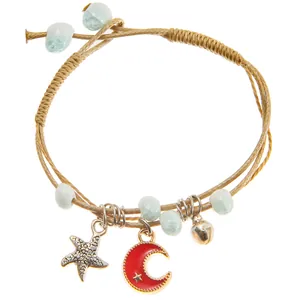 Detailed macro of ceramic bead bracelet with silver starfish and golden moon charms