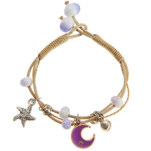 Detail of hand-woven bracelet with starfish moon charms and purple beads in macro view