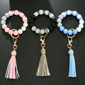 Makroaufnahme von Silikon-Perlenarmbändern mit LOVE-Anhängern und PU-Lederquasten-Details