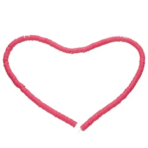 Vibrant rose red clay heishi beads arranged in heart shape for DIY jewelry making