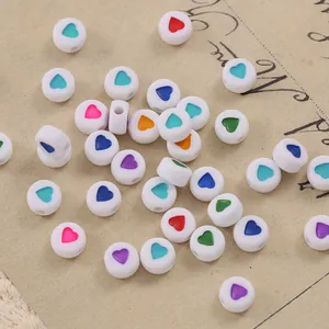 Close-up of 7mm white flat round resin beads with colorful heart centers for DIY jewelry