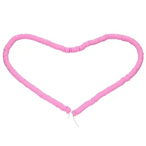 Pink polymer clay heishi beads arranged in a heart shape for DIY jewelry making