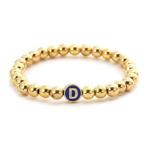 Fashionable gold beaded elastic bracelet with a blue enamel letter D charm pendant