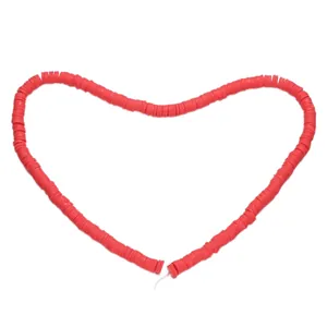 Vibrant red polymer clay heishi beads arranged in a heart shape for DIY jewelry crafting