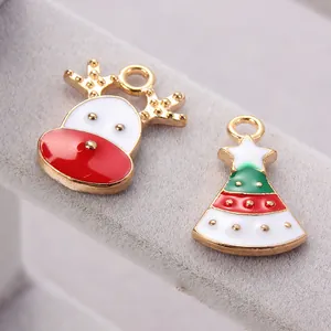 Macro detail of Christmas elk and tree enamel pendants with gold plating for jewelry making