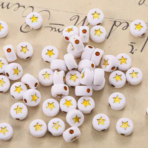 Macro shot of white acrylic round beads with gold star pattern and side threading holes