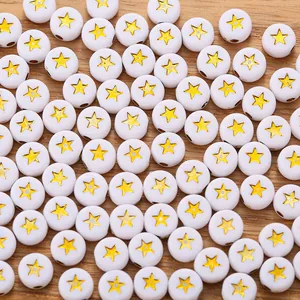 Macro view of white resin beads with yellow star patterns for DIY jewelry making