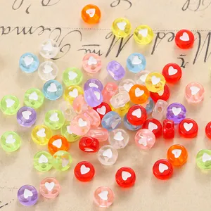 Flat lay of colorful acrylic heart beads on vintage paper for DIY jewelry making