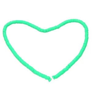 Green clay heishi beads arranged in a heart shape for DIY necklace jewelry making