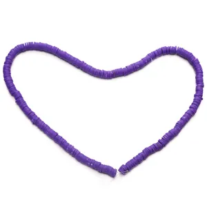 Detailed view of 6mm deep purple flat clay heishi beads arranged in a heart shape