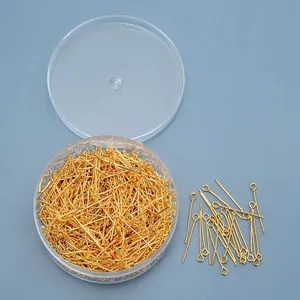 Macro-opname van gouden oogspelden voor DIY-sieraden in een ronde plastic doos