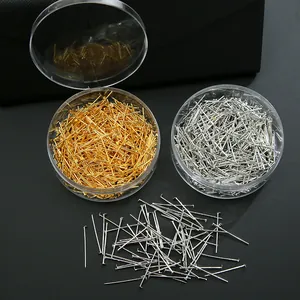 Detail van zilveren en gouden T-pennen in ronde doosjes voor DIY sieraden en ambachten