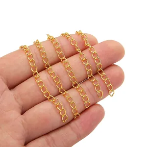 Golden stainless steel extension chain for DIY necklaces held by hand on white background